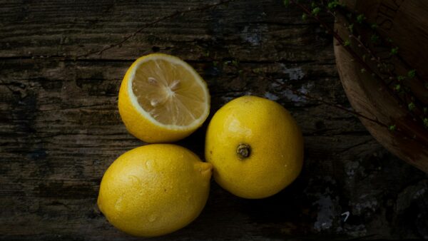 Top view of fresh lemons on a rustic wooden table, perfect for natural themes.