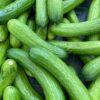 Close-up of fresh organic cucumbers displayed at a local farmers market, perfect for healthy eating.