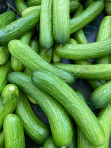 Close-up of fresh organic cucumbers displayed at a local farmers market, perfect for healthy eating.