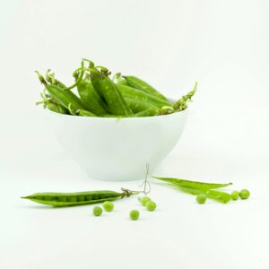 Close-up of fresh green peas in a white bowl. Perfect for healthy eating concepts.